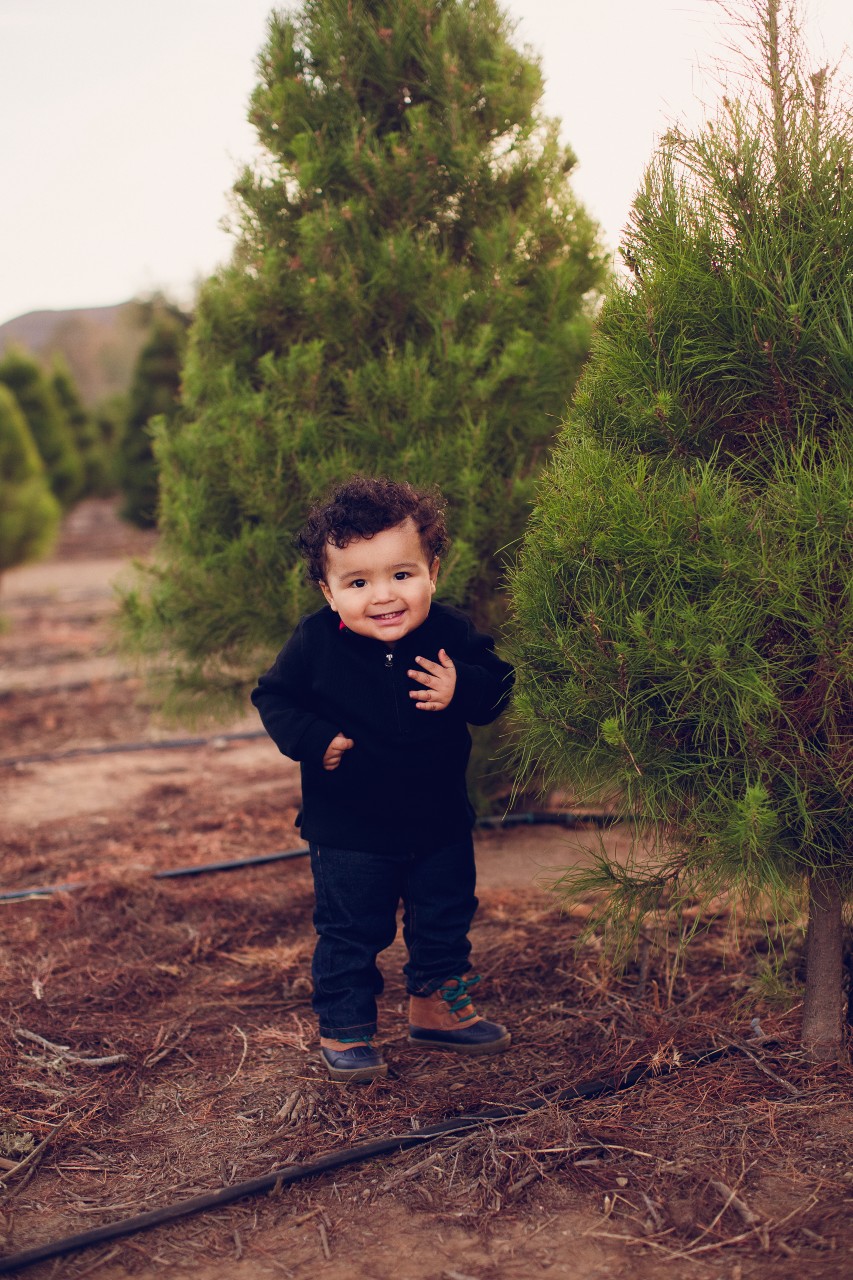 Little boy standing in front of a Christmas tree